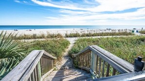 A wooden boardwalk leading to a beach with clear skies and calm waters. - Ocean Park Private, Luxurious & Incredible Views (Myrtle Beach)