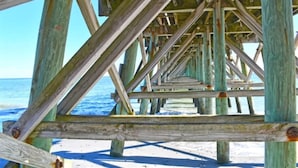 A wooden pier structure with a clear view of the ocean and sandy beach. - New Top Floor Direct Oceanfront with Amazing View! (Myrtle Beach)