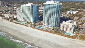 A coastal hotel with multiple high-rise buildings, a beachfront, and a pool area. - New Top Floor Direct Oceanfront with Amazing View! (Myrtle Beach)