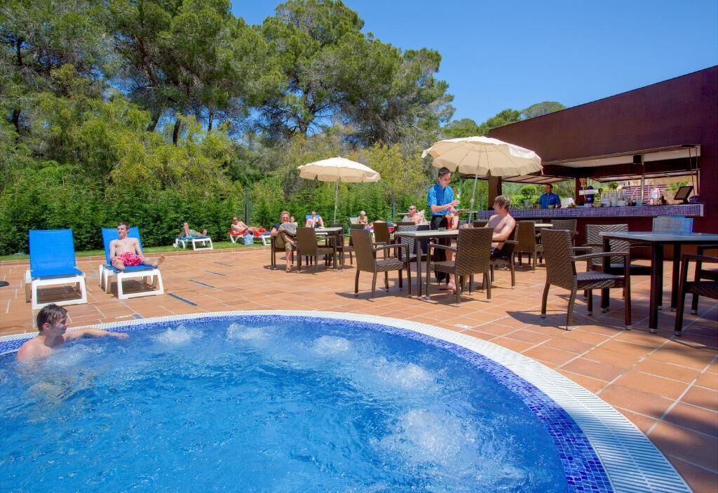 Una piscina cubierta, una piscina al aire libre, sombrillas, tumbonas
