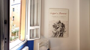 Een knus verblijf met een kitchenette, een bank, een eettafel en een boekenkast.
