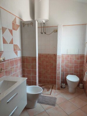 A bathroom with a shower, toilet, sink, and a towel rack. - Sea view, Pleasant house in the heart of olive groves in the countryside (Murta Maria)