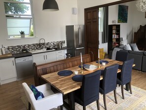 Eine moderne Küche mit eingebautem Geschirrspüler, Kühlschrank und Essbereich mit Holztisch und Stühlen.