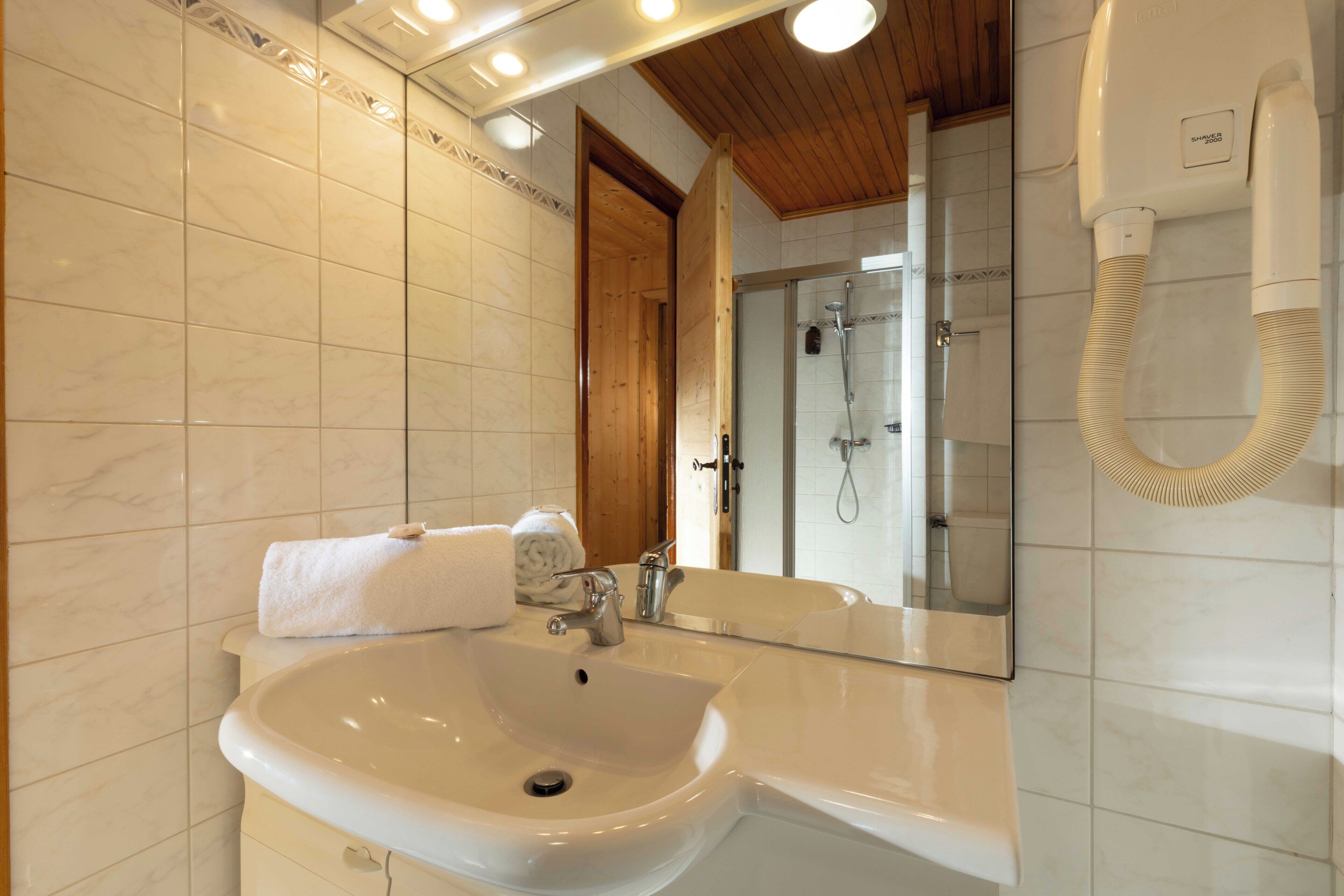 Ein Badezimmer mit Waschbecken, Spiegel und Dusche.