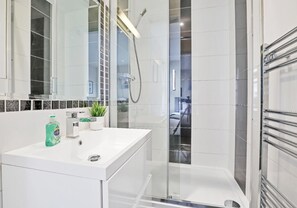 Kombination af bruser/badekar, hårtørrer, håndklæder