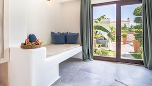 A room with a built-in bench, a large sliding glass door to an outdoor area, and a wall-mounted light fixture.