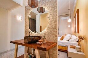 A modern bathroom with a large round mirror, wooden vanity, and a large sink. - Discover Athens from an Upscale flat in Koukaki! (Αθήνα)