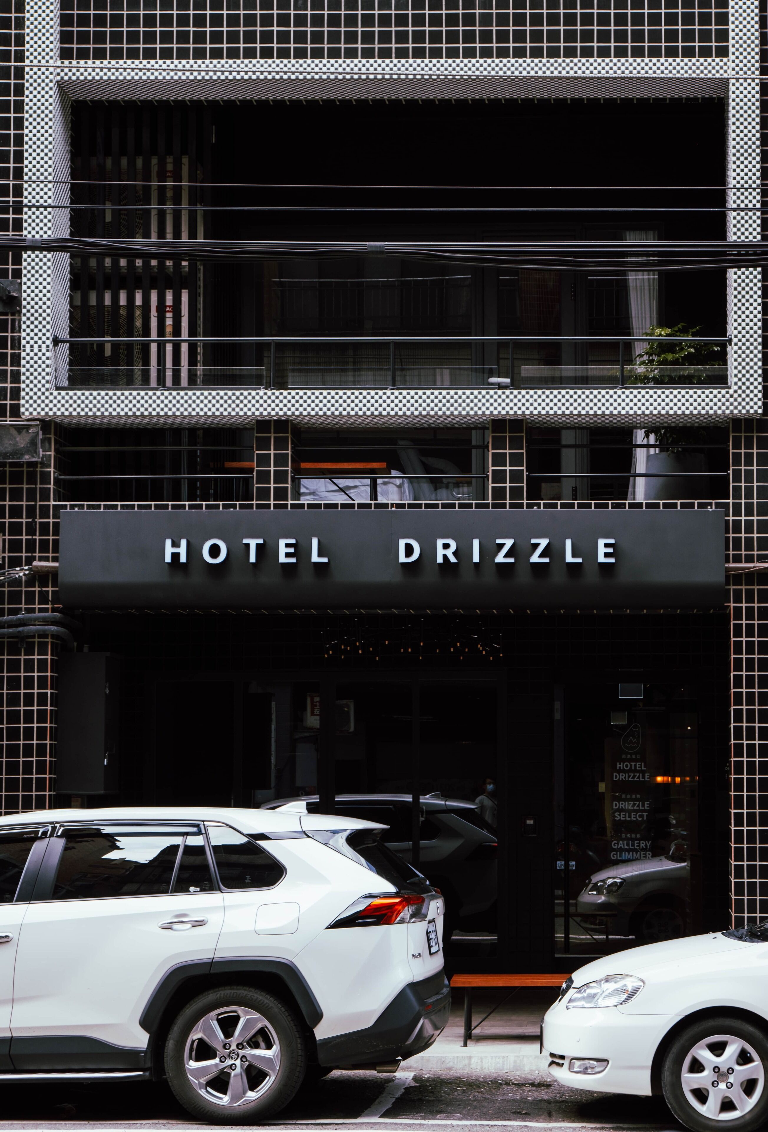 A hotel entrance with a sign reading "HOTEL DRIZZLE".
