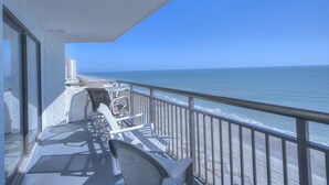 A balcony with a view of the ocean, a railing, and a few chairs. - Bluewater Resort 902 - Beautiful 2 Bedroom/2 Bath Condo, Ocean Front View, Indoor/Outdoor pool, Hot Tub (Myrtle Beach)