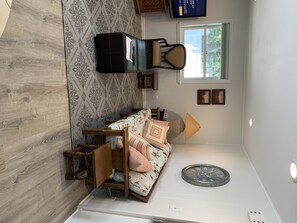 Cozy retreat with a bed, side table, and wall-mounted TV.