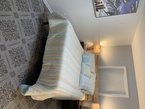 Restful retreat with a large bed, patterned rug, and wall-mounted lamp.