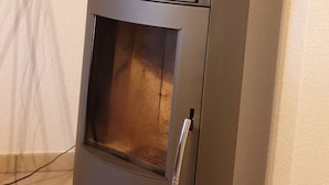A modern, compact wood stove with a glass door and a chimney. - Lüneburg 0 meters? Welcome! Beautiful 95 sqm, 3 rooms, 1-6 pers., large bathroom, garden (Reppenstedt)