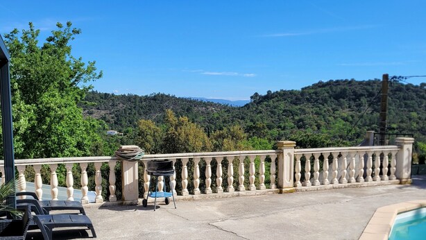 A pool area with a stone balustrade, lounge chairs, and a view of a forested hillside. - Villa with breathtaking view of the Massif des Maures (Vidauban)