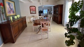 A dining area with a wooden table and chairs, a cabinet, and a potted plant. - Villa with breathtaking view of the Massif des Maures (Vidauban)