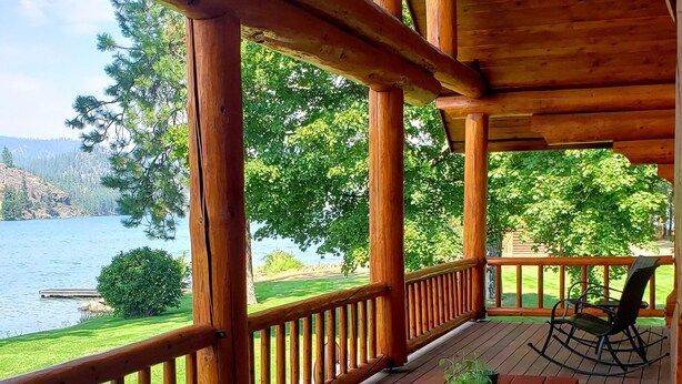 A wooden deck with a view of a lake and hills.