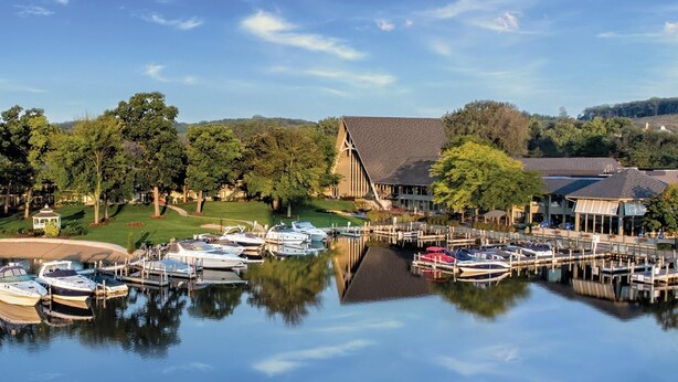 A marina with boats docked, a church with a steeple, and a building with a sloped roof.