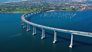 A long bridge with multiple support pillars extending into a body of water, surrounded by a coastal town. - Canyon View Tranquil Oasis, Private Pool and Dreamy Sunsets, New Backyard (San Diego)