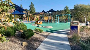 A playground with slides, climbing structures, and shaded areas. - Canyon View Tranquil Oasis, Private Pool and Dreamy Sunsets, New Backyard (San Diego)