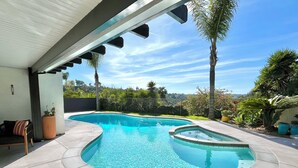 A swimming pool with a curved design, surrounded by a tiled deck and palm trees. - Canyon View Tranquil Oasis, Private Pool and Dreamy Sunsets, New Backyard (San Diego)