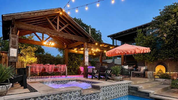 A pool area with a hot tub, outdoor seating, and string lights. - Backyard Resort: Heated Pool, Spa & Putting Green (Fort Worth)