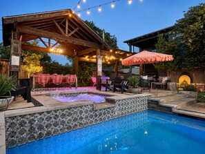 A pool area with a hot tub, outdoor seating, and string lights. - Backyard Resort: Heated Pool, Spa & Putting Green (Fort Worth)