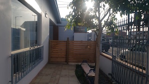 A courtyard with a wooden gate, a bench, and a tree. - Pura Vida Casita Retreat: Temp-control heat+more modern conveniences for comfort (Ensenada)