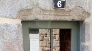 A stone-framed door with a number '6' above it, a window, and a door handle. - La Maison de Félicie (Saint-Pol-de-Léon)