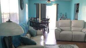 A living room with a sofa, a coffee table, a lamp, a patterned rug, and a ceiling fan. - Peaceful, close to water attractions & Fishing (Panama City)