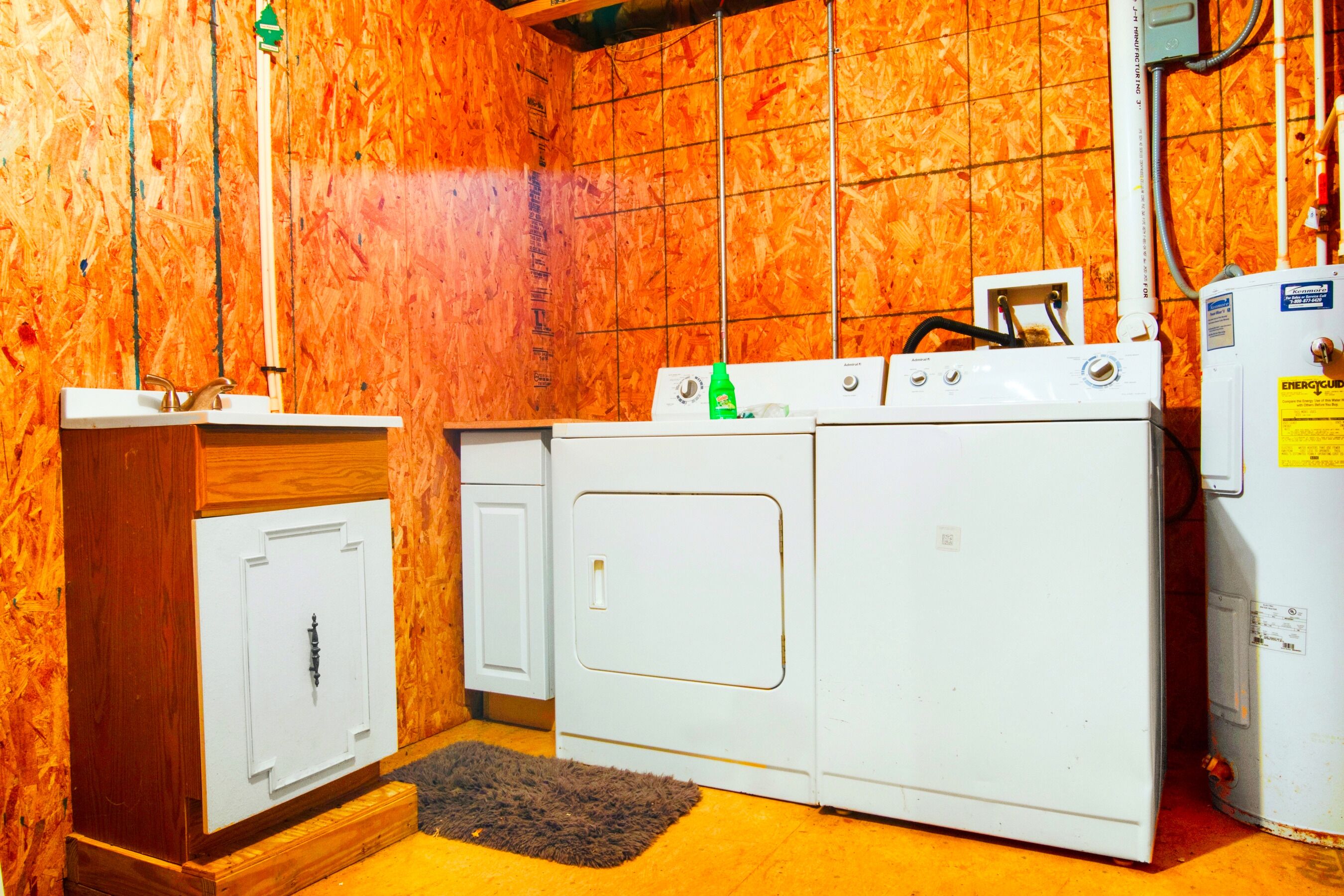 A laundry room with a washing machine, dryer, and a cabinet.