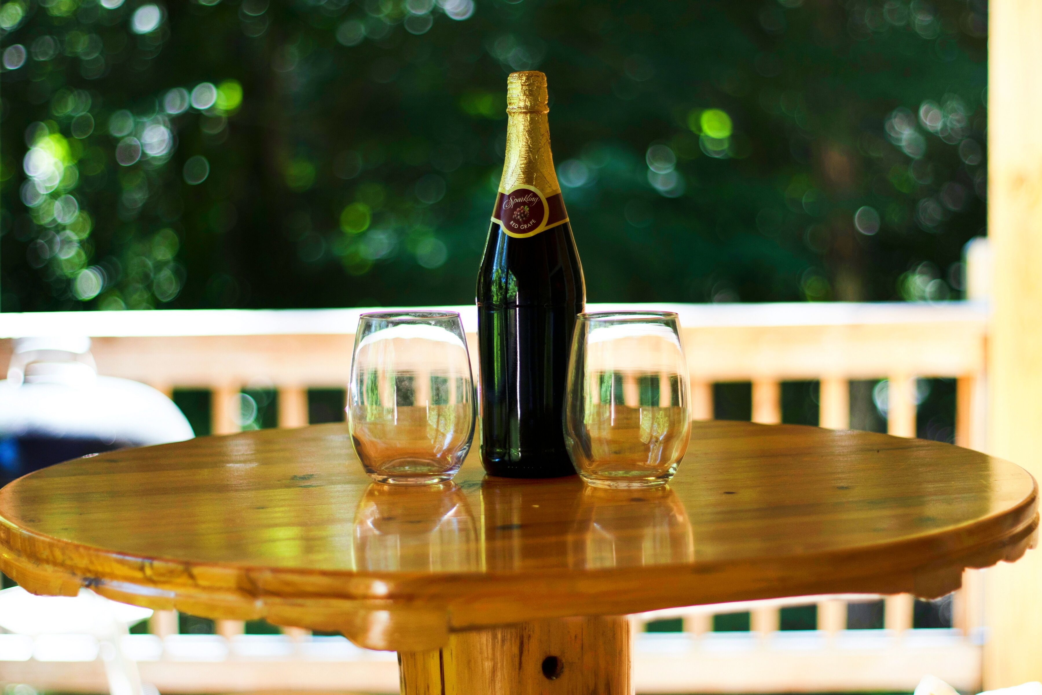 Une table en bois sur laquelle se trouvent une bouteille de champagne et deux verres.