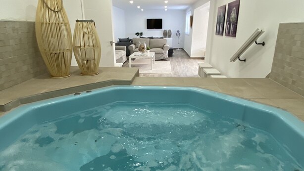Ein moderner Innenpool mit freiem Blick auf einen Wohnbereich im Hintergrund.