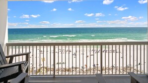 Een balkon met uitzicht op een strand en zee.