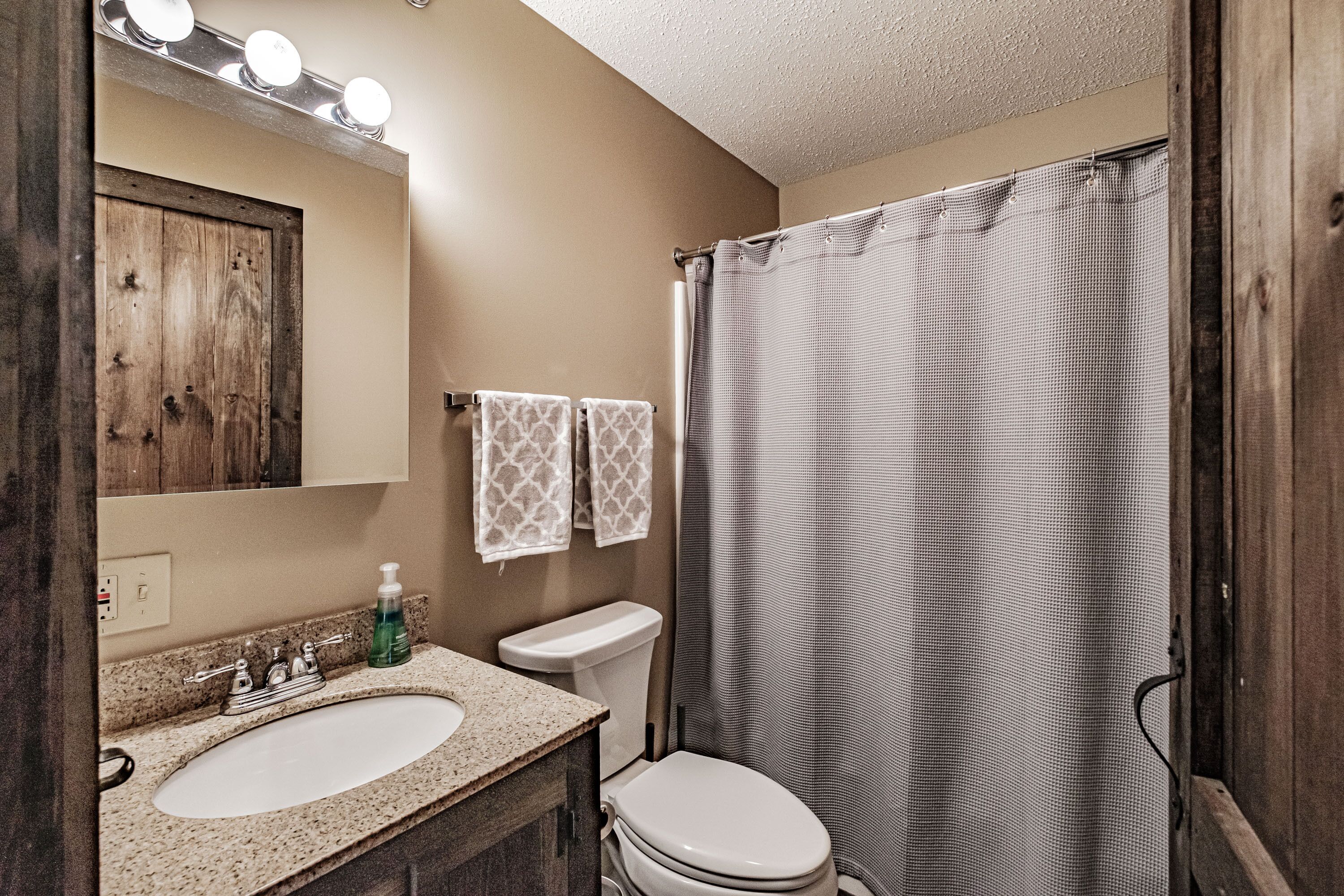 A bathroom with a sink, mirror, and toilet.
