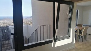 A modern apartment with a balcony, a dining area, and a view of the cityscape. - VILLA "LA FLORIDA" - WONDERFUL VIEWS - POOL - WIFI (CN)