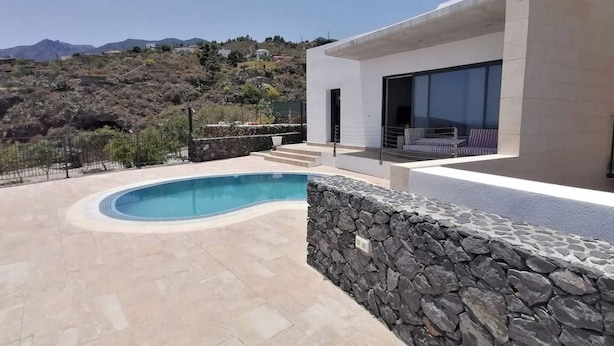 A modern house with a swimming pool, stone wall, and a view of mountains. - VILLA "LA FLORIDA" - WONDERFUL VIEWS - POOL - WIFI (CN)