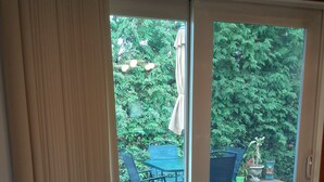 Ein Zimmer mit einer Schiebetür zu einer Terrasse im Freien, komplett mit Tisch und Stühlen.