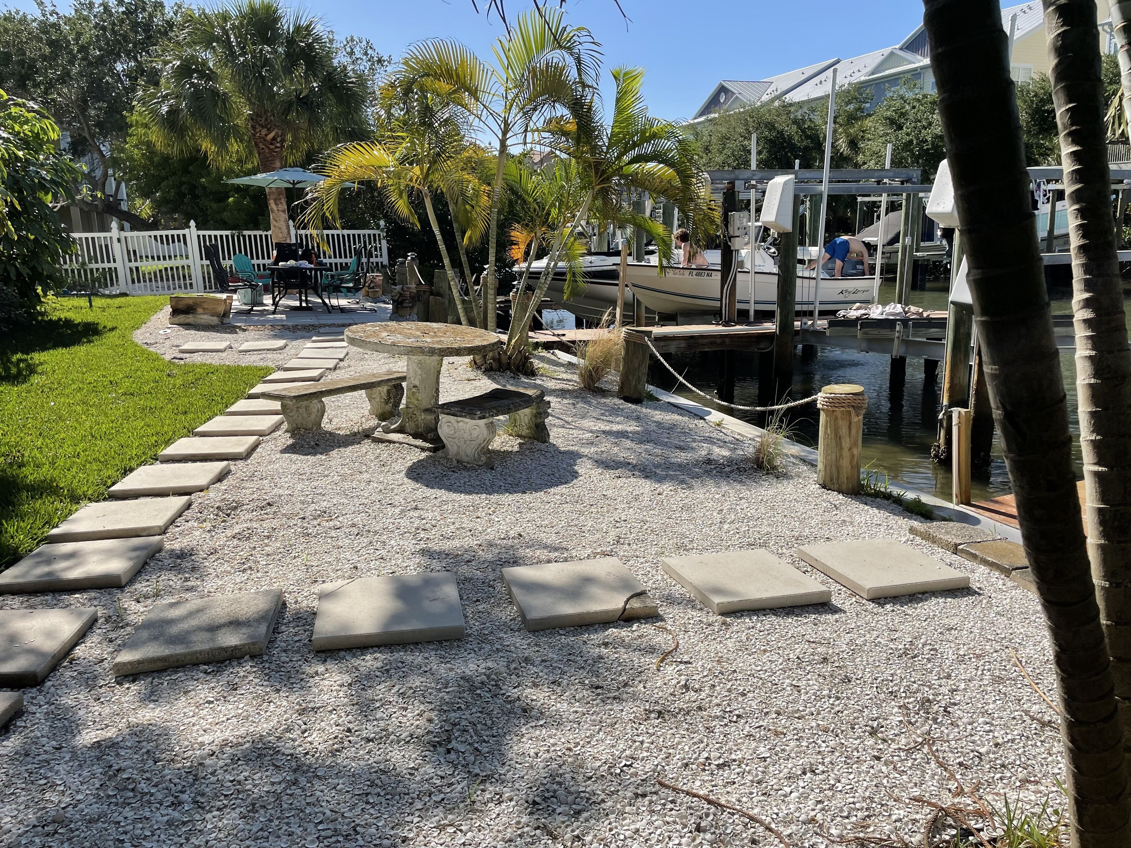 A waterfront patio with stone benches and a dock.