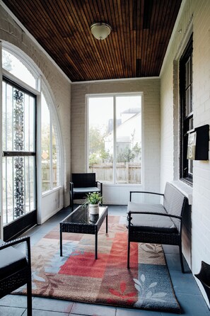 A sunlit room with a wooden ceiling, large windows, and a colorful rug. - You're minutes away — but when everybody comes back, you're not returning to separate hotel rooms. Two bedrooms. Real kitchen. Laundry. Room to live normally. Pets can come too. (Montgomery)