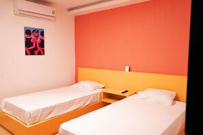 Two single beds with white mattresses and pillows, a nightstand, and a mounted air conditioning unit.