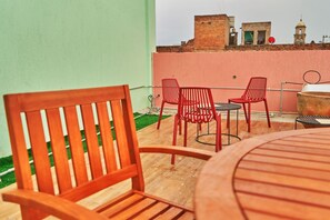 Relax and dine in this outdoor seating area with a grill, surrounded by a green wall and scenic views.