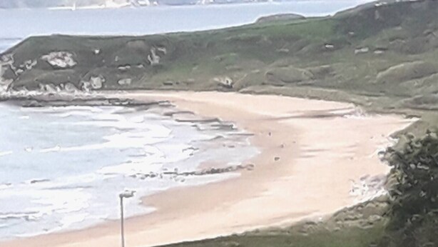 A coastal landscape with a sandy beach, grassy hills, and rocky cliffs. - Lovely 1-Bed Apartment at Whitepark Bay Co Antrim (Bushmills)