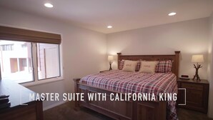 Una suite principale con un letto king size California, una testiera in legno, due comodini con lampade e una finestra con persiane.