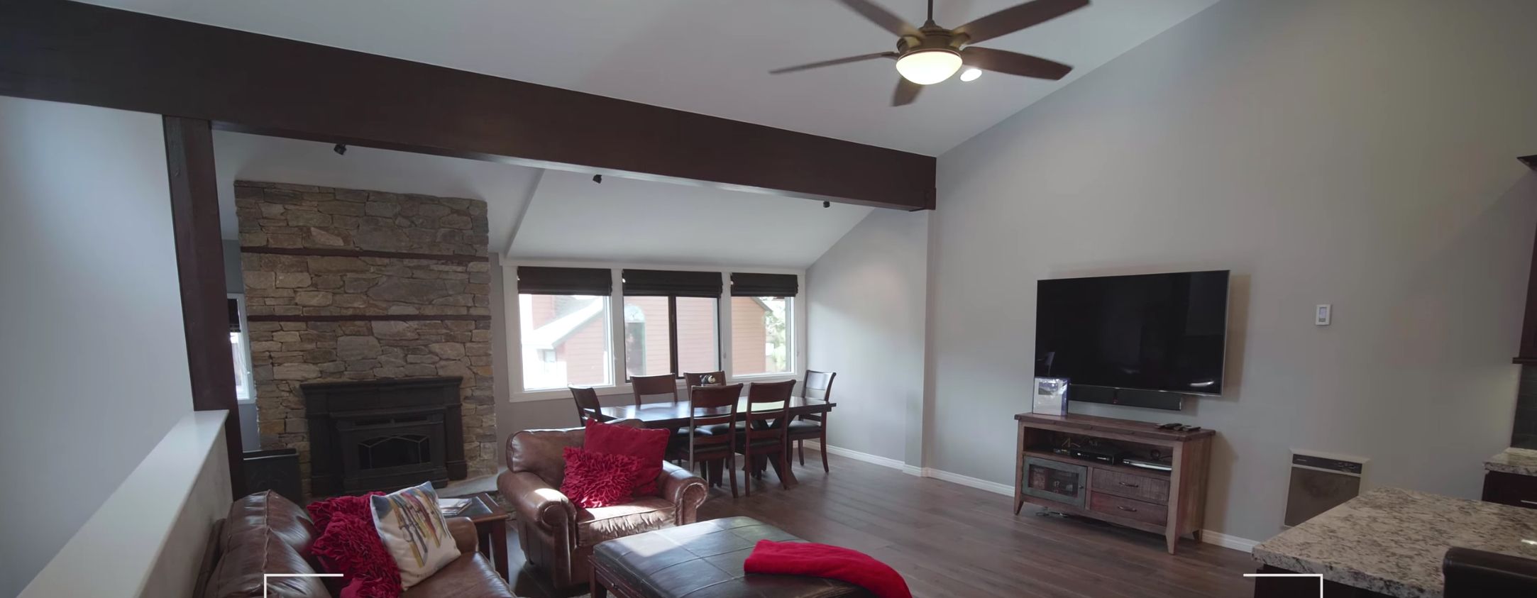 A spacious living room with a fireplace, a dining area, and a kitchen.
