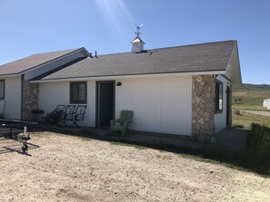 A single-story building with a stone exterior and a white door.