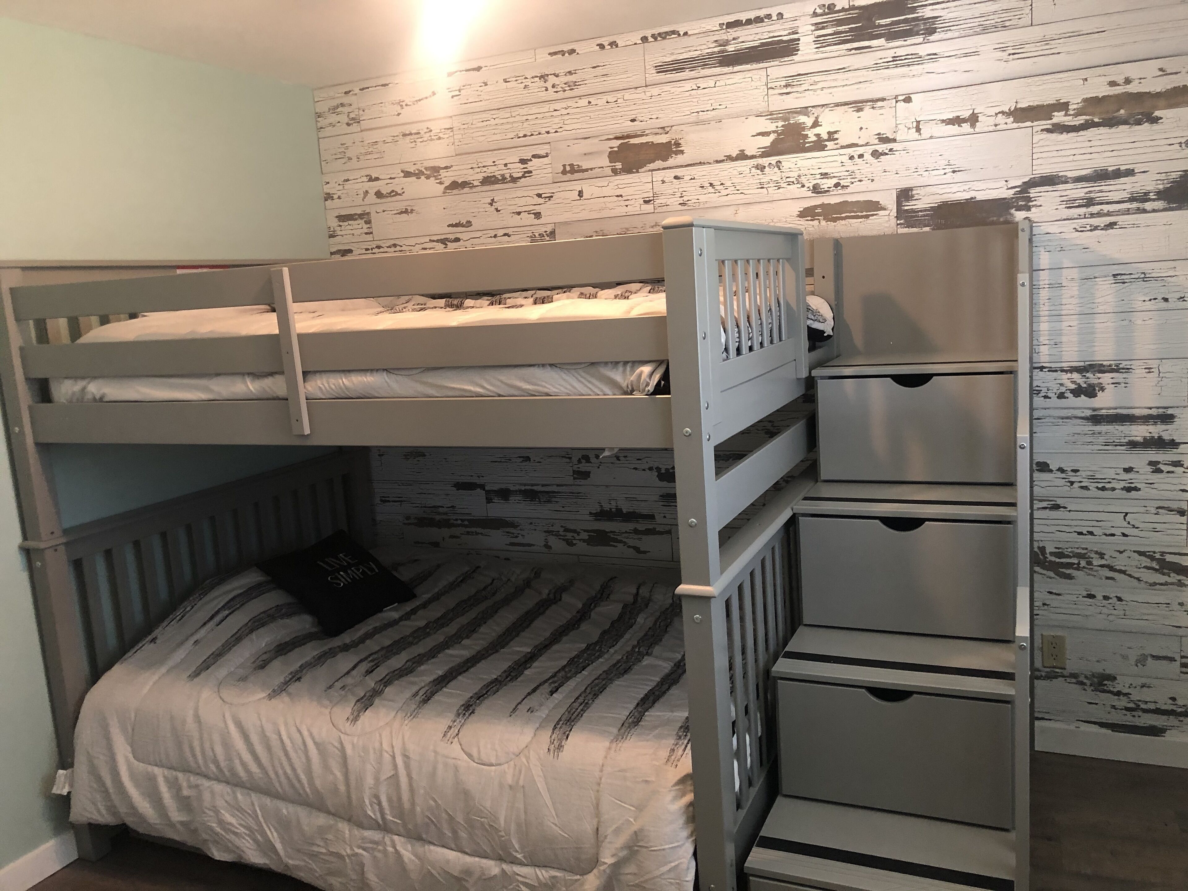 Una cama litera con una cama inferior y un espacio de almacenamiento debajo.