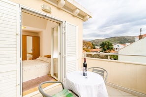A balcony with a table, a chair, and a bottle of wine. - Relaxing Duplex Apartment A3, Close to the Sunset Beach Near Dubrovnik, 2-4 (Dubrovnik)