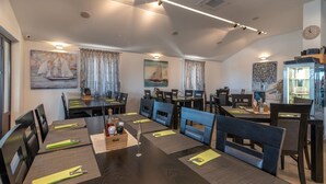 Comedor con varias mesas y sillas, dispuesto en un espacio amplio.