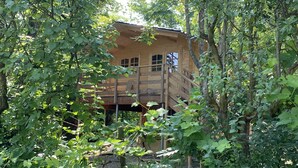 A wooden cabin surrounded by dense foliage. - Holiday House Sullalbero Rural eco in Alba (Alba)
