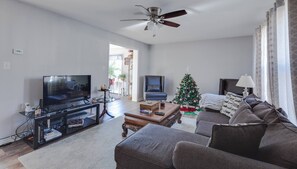 Ett vardagsrum med en tv, en soffa, ett soffbord och en julgran.