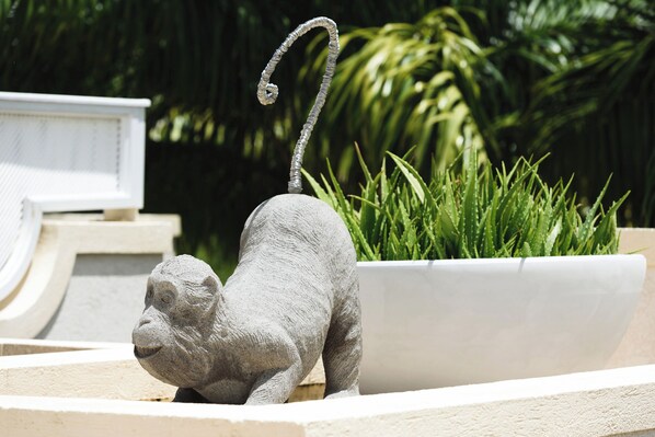 Una escultura de piedra de un mono en una maceta.